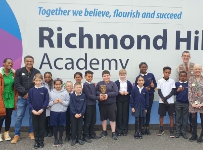 Shanequa Paris (left), Waqar Ahmed, and Ben Shires (right) standing in front of the Richmond Hill Academy sign with pupils. Two children are smiling while holding the BAFTA trophy. Shanequa Paris (left), Waqar Ahmed, and Ben Shires (right) standing in front of the Richmond Hill Academy sign with pupils. Two children are smiling while holding the BAFTA trophy.