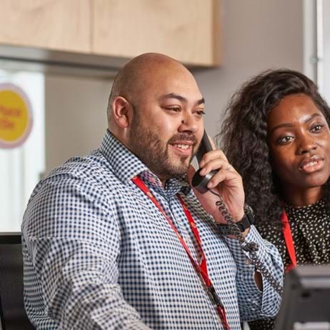 Person on phone at Place2Be alongside a colleague