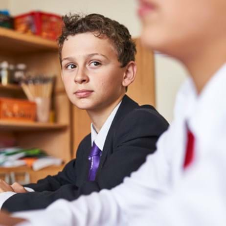 two school children at desk in classroom