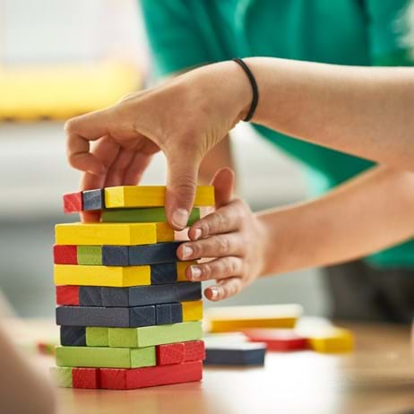 Children's hands with building blocks in different colours