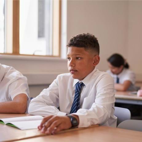 secondary-aged boy sitting in a classroom