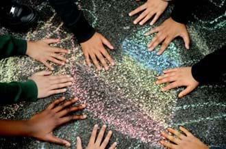 children putting their hands on a heart drawn in chalk on a playground