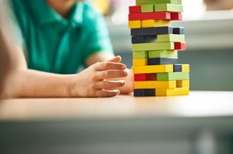 Child with colourful building blocks in school classroom