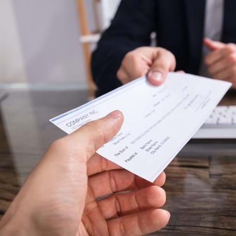 Person handing a cheque to another person