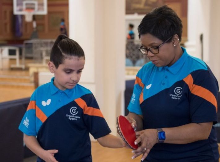 A woman and a child preparing to play table tennis