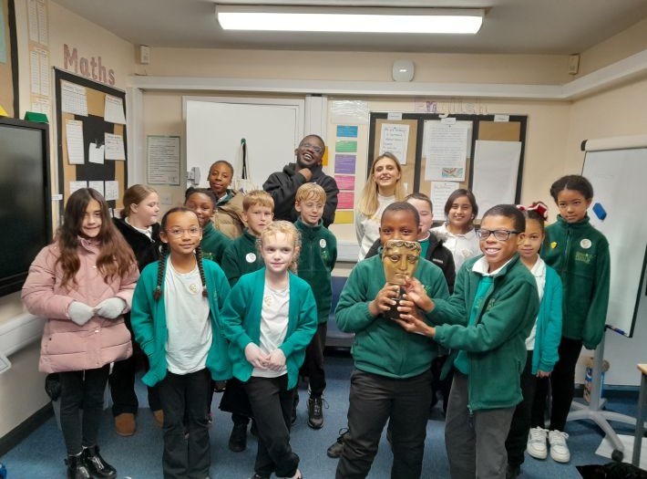 Pupils from Robin Hood primary school standing, holding a BAFTA replica trophy, with presenters De-Graft Mensah and Kia Pegg