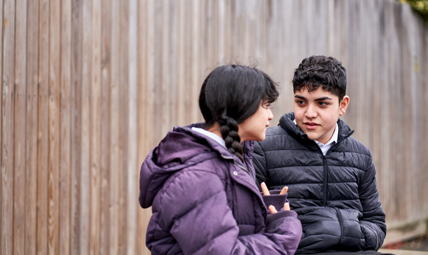 Two students sat outside, having a conversation