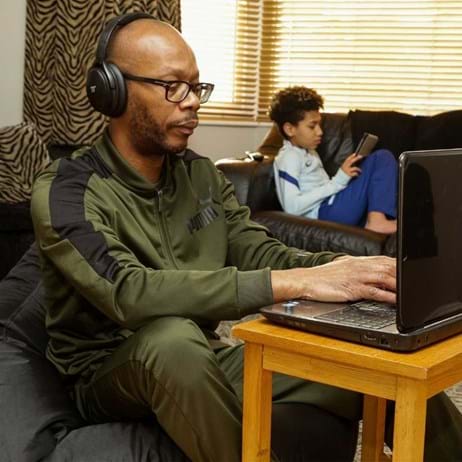 person wearing headphones on laptop