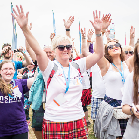 Group of walkers with arms raised in air