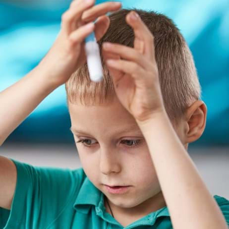 Boy holding pen with hands in the air