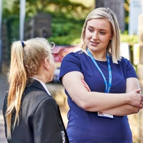 School staff member talking to young people